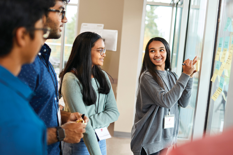 Teens holding a marker while planning a project together